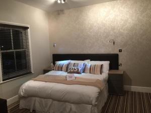 a bedroom with a large bed with pillows on it at The Mowbray in Eastbourne