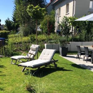 2 Liegestühle und ein Tisch im Hof in der Unterkunft Tolle Ferienwohnung Le Gira mit eigenem Garten in Konstanz