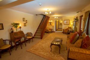a living room with a staircase and a couch and a table at Springburn Farmhouse in Spean Bridge