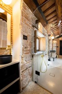 a kitchen with a stone wall and a glass door at Spirito Santo Palazzo Storico in Rovinj