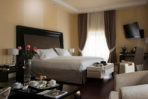 a hotel room with a bed and a living room at GH Palazzo Suite & SPA in Livorno