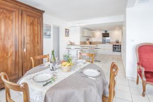 a dining room with a table and a kitchen at Le Matelot in Erquy +4 photos