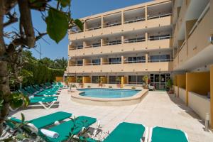 an image of a hotel with lounge chairs and a swimming pool at Alper Apartments Mallorca in Palmanova