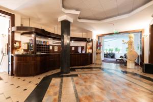 a lobby with a bar with a statue of a woman at Villa Pallas in Olsztyn