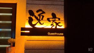 un cartello sul lato di un edificio che dice "pensione" di 逸家民宿 Yija a Wujie