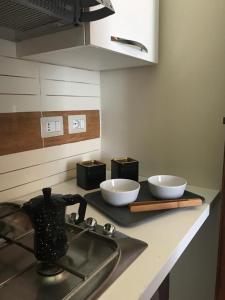 a kitchen counter with two bowls and a kettle on a stove at appartamento Vintage in Torrenova +1 photo