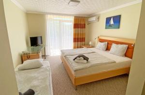een slaapkamer met een bed met een knuffeldier erop bij Solaris Hotel in Balatonföldvár