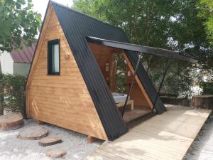 a tiny house with a black roof at Solmeco Park in Aldeia do Meco