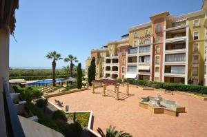 a courtyard with a picnic table and benches in front of a building at Apartamentos Solmares in Isla Canela