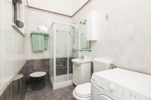 une salle de bain blanche avec toilettes et douche dans l'établissement SeaView Studio, à Umag