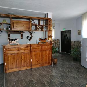 a kitchen with wooden cabinets and a refrigerator at Guesthouse White Margarit in Melnik