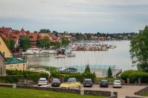 a group of cars parked in a parking lot next to a harbor at Willa Tabu - Mikołajki Centrum in Mikołajki