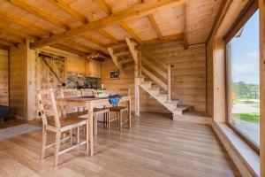 a dining room with a table and chairs in a log cabin at Chaty Jak Dawniej in Wołkowyja