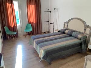1 dormitorio con 1 cama y 2 sillas en Apartamento Salomé, en Padrón
