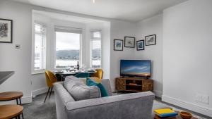 a living room with a couch and a television at Station Approach in Deganwy