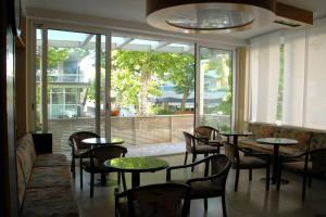 un ristorante con tavoli e sedie e una grande finestra di Hotel Arno a Rimini