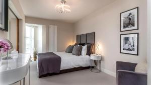 1 dormitorio con cama y lámpara de araña en Castle Penthouse, en Deganwy