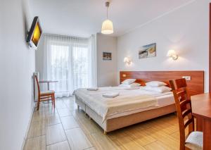 um quarto com uma cama, uma secretária e uma mesa em Marina em Ostrowo