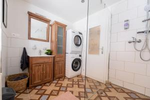 a bathroom with a washing machine and a shower at Flora Apartment Kosice Center in Košice +26 photos