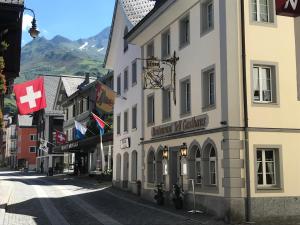 una calle en una ciudad con edificios y banderas en Gasthaus Tell, en Andermatt