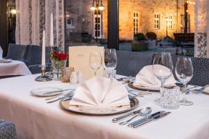 una mesa con cubiertos y servilletas sobre un mantel blanco en Göbels Schlosshotel "Prinz von Hessen", en Friedewald