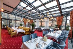 een restaurant met tafels en stoelen en glazen plafonds bij Göbels Schlosshotel "Prinz von Hessen" in Friedewald