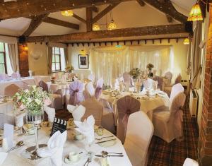 a room filled with tables and chairs with white table cloth at Slaters Country Inn in Whitmore