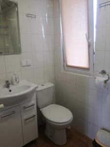 a white bathroom with a toilet and a sink at Słoneczne Zacisze in Miłomłyn