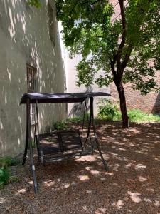 una mesa de picnic frente a un edificio con un árbol en La Meridiana, en Piacenza