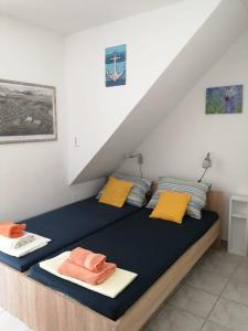 a bed with yellow and orange pillows in a room at Apartments Viking in Split