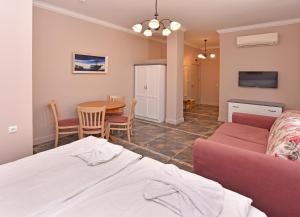 a living room with a bed a table and a couch at Sirena Palace Family Hotel in Obzor