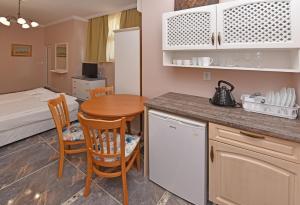a kitchen and dining room with a table and a bed at Sirena Palace Family Hotel in Obzor