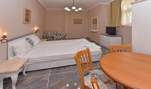 a bedroom with a bed and a table and chairs at Sirena Palace Family Hotel in Obzor