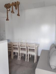 a white dining room with a table and chairs at Aletri & Orgoma in Vathi