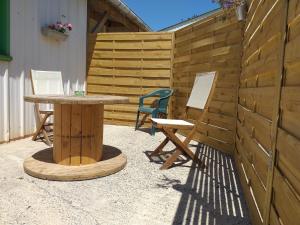 un patio con mesa, sillas y una valla en L'appart, en La Chapelle-de-Brain