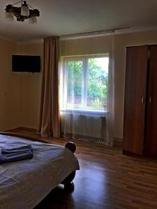 a bedroom with a bed and a large window at N V New View in Yaremche