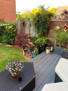 un patio con una mesa y algunas plantas y flores en Lichfield City Home en Lichfield
