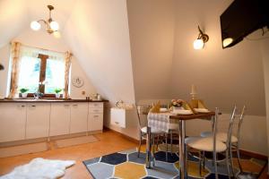 a kitchen and dining room with a table and chairs at Zakątek u Pary in Biały Dunajec