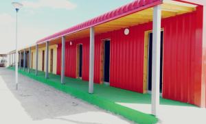 ein rotes und grünes Gebäude mit Straßenbeleuchtung in der Unterkunft Albergue Centro de Ocio Luis Miguel 