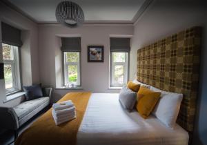 a bedroom with a large bed with yellow pillows at Mary's Court Guest House - Mairlys in Betws-y-coed