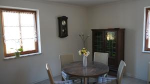 a dining room with a table with chairs and a clock at Rittergut zu Groitzsch in Jesewitz