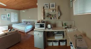 Whale of a Time - Sedgefield في سيدجفيلد: غرفة معيشة مع سرير ومطبخ صغير