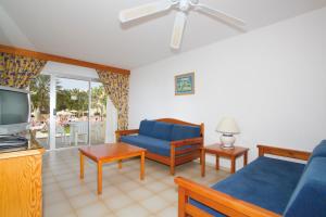 a living room with a blue couch and a tv at Hotel Riu Oliva Beach Resort - All Inclusive in Corralejo