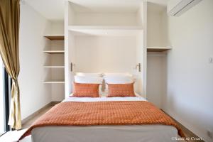 um quarto com uma cama com almofadas laranja e branca em Casa di Neshama Ghjiseppu em Saint-Florent