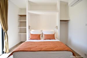 a bedroom with a bed with orange and white pillows at Casa di Neshama Ghjiseppu in Saint-Florent