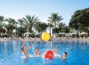 a group of people playing with a ball in a swimming pool at Hotel Riu Oliva Beach Resort - All Inclusive in Corralejo