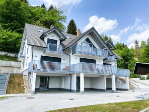 布莱德Lakeview Villa Bled的车道上设有蓝色阳台的白色房子