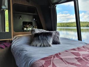 um quarto com uma cama e vista para a água em AuroraHut, Overwater Hut em Kuusamo