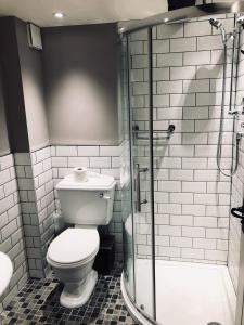 a bathroom with a toilet and a glass shower at The Golden Pheasant Hotel in Burford
