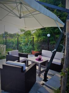un patio con una mesa y una sombrilla blanca en L'ARCA affittacamere en Fucecchio